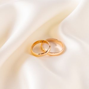 Two,Gold,Classic,Wedding,Rings,Lie,On,A,Chic,Satin