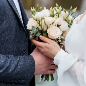 Elegant,Wedding,Couple,Holding,A,Beautiful,Bouquet,Of,White,And