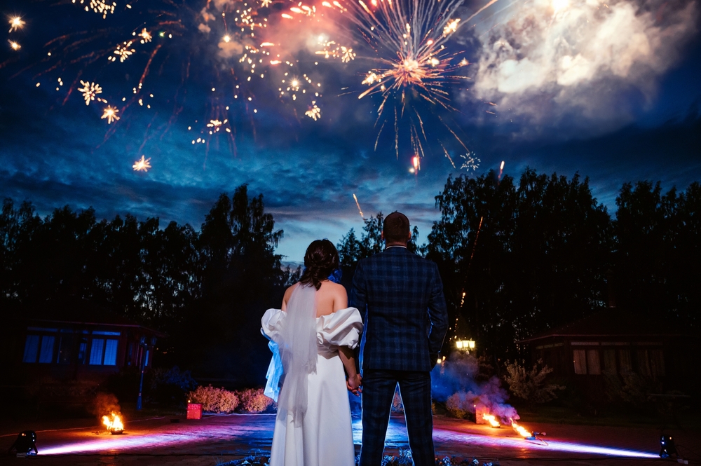 Bride,And,Groom,Stand,With,Their,Backs,Against,The,Background